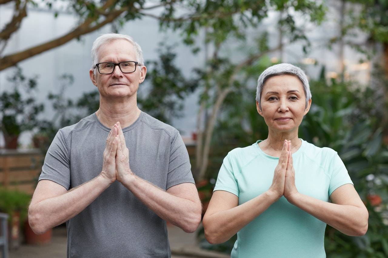 OlderHealthyCouple_Namaste Older Healthy Couple Joined Hands