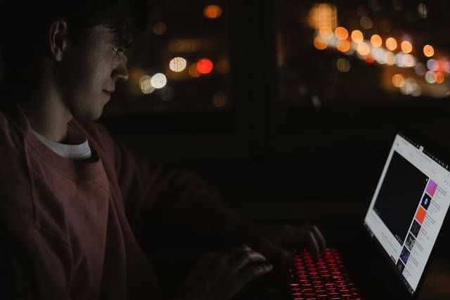 Guy On Computer In The Dark Room