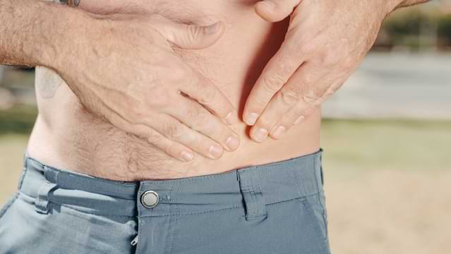 man touching his gut